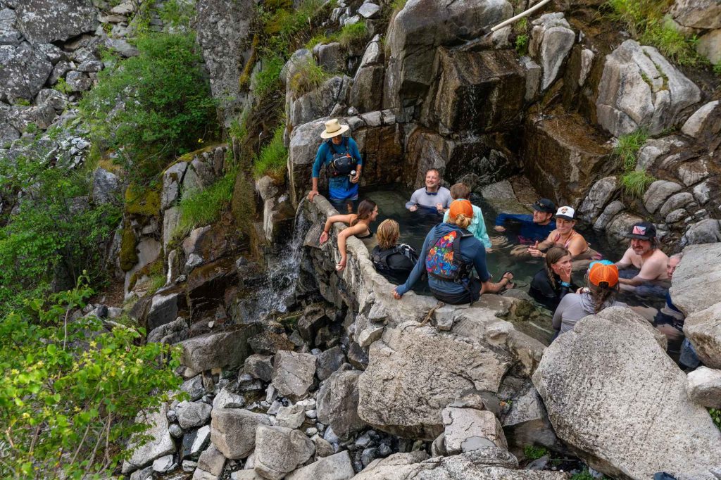Landing Page Adventurers pause for a dip in the rugged Barth Hot Springs, high in the wilderness.
