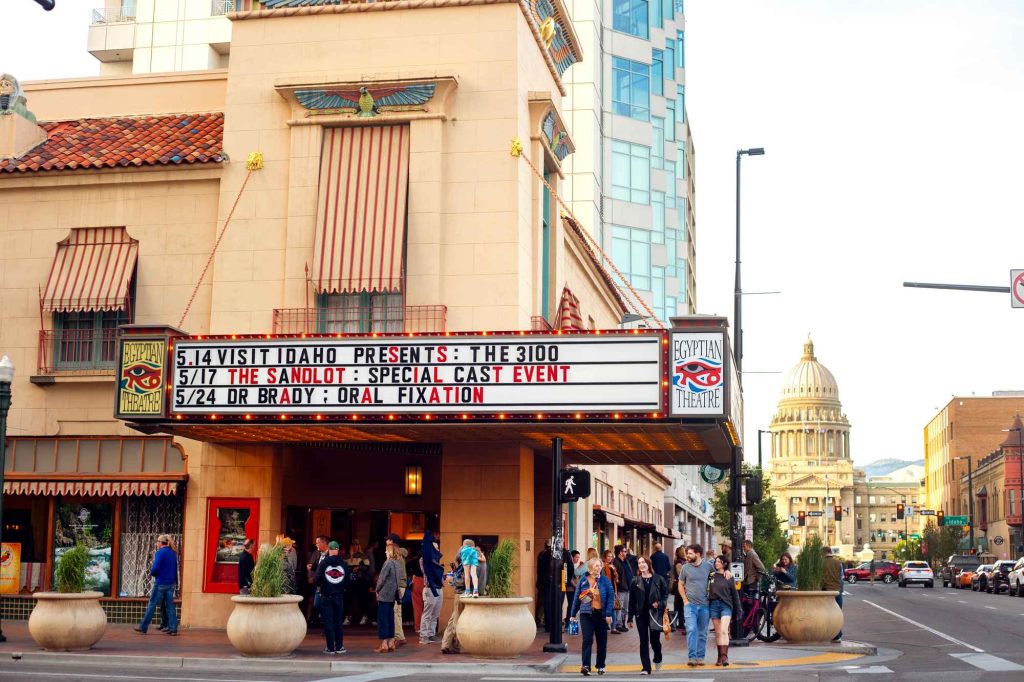 Landing Page The Egyptian Theatre marquee twinkles as crowds gather outside, the sign reading, “Visit Idaho Presents The 3100.”
